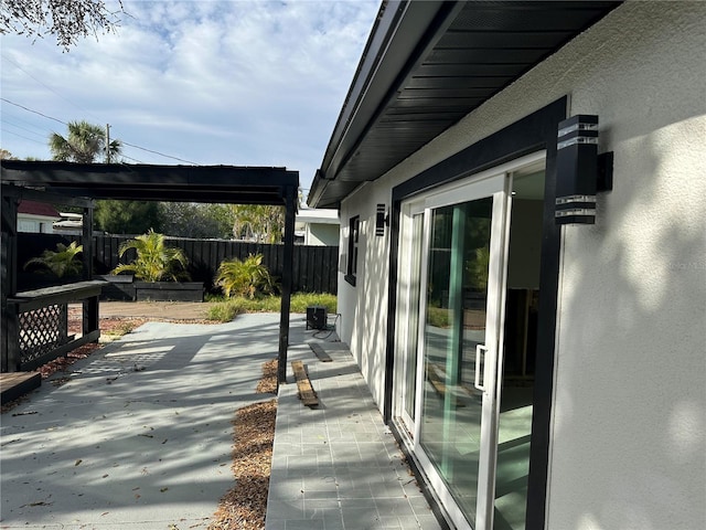 exterior space featuring stucco siding, fence, and a patio