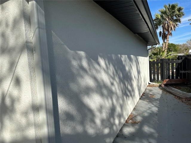 view of property exterior with fence and stucco siding