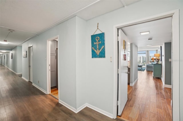 corridor featuring baseboards and wood finished floors