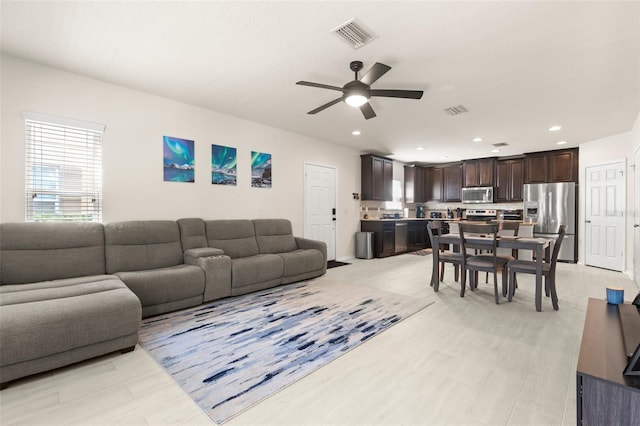 living room featuring visible vents, a ceiling fan, and recessed lighting