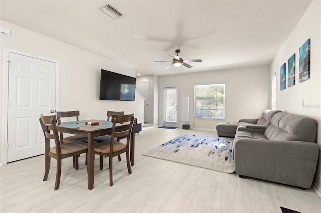 living area featuring visible vents and ceiling fan