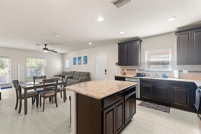 kitchen with a sink, a healthy amount of sunlight, visible vents, and dishwasher