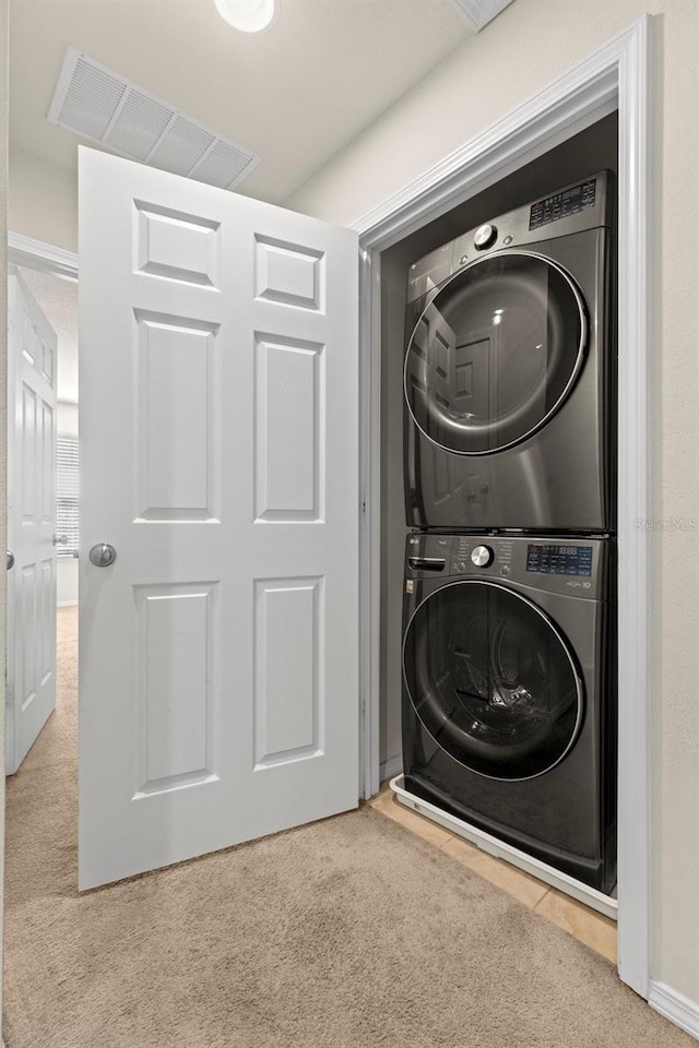 washroom featuring laundry area, carpet, visible vents, and stacked washer and clothes dryer