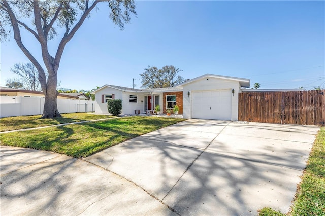 single story home with a front lawn, concrete driveway, fence, and an attached garage