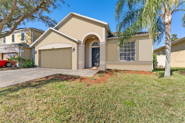 ranch-style home featuring a garage, driveway, a front yard, and stucco siding