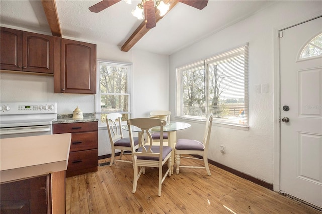 dining space with a healthy amount of sunlight, light wood-style flooring, baseboards, and beamed ceiling