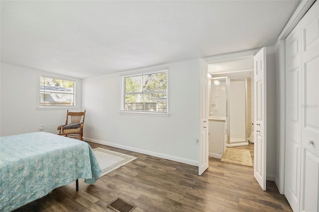 bedroom featuring a closet, visible vents, baseboards, and wood finished floors