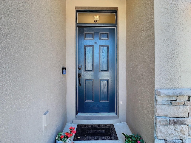 view of exterior entry featuring stucco siding