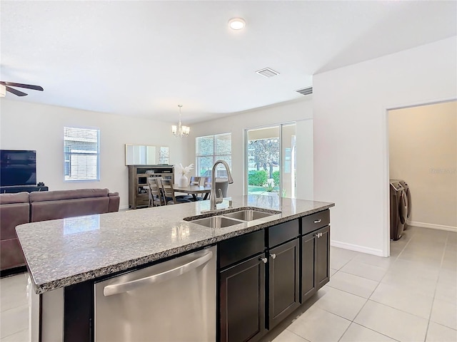 kitchen with washing machine and dryer, a sink, open floor plan, dishwasher, and a center island with sink