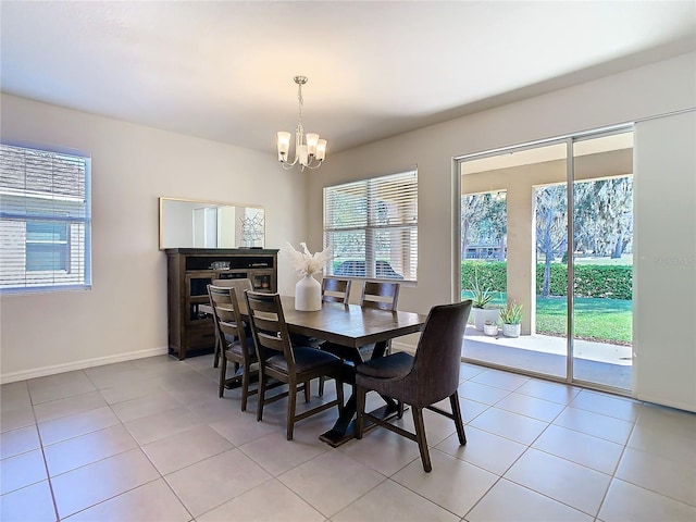 dining room with light tile patterned floors, baseboards, and a notable chandelier