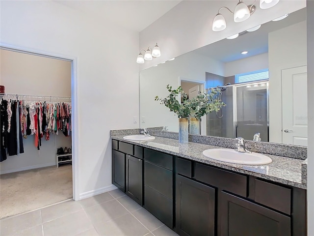 full bath with double vanity, a stall shower, tile patterned flooring, and a sink