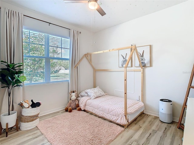 bedroom with ceiling fan, baseboards, and wood finished floors