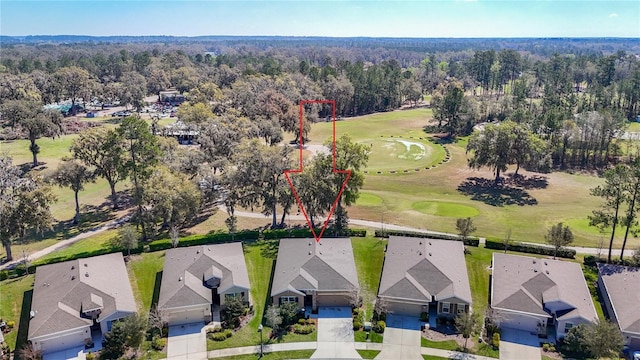 birds eye view of property featuring view of golf course, a forest view, and a residential view