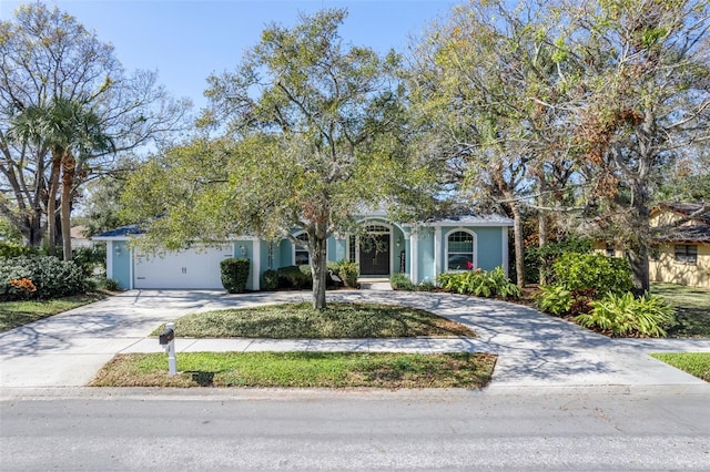 view of front of property with driveway, an attached garage, and stucco siding