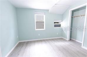 unfurnished bedroom with a closet, baseboards, and wood finished floors