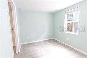 spare room featuring baseboards and wood finished floors