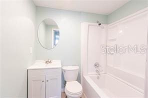 bathroom with bathtub / shower combination, vanity, and toilet