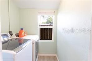 laundry room with laundry area, washing machine and clothes dryer, and baseboards