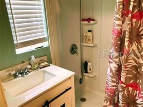 full bath with a shower with shower curtain and vanity