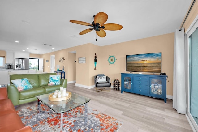 living area featuring recessed lighting, baseboards, ceiling fan, and light wood finished floors