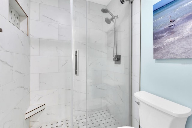 full bathroom featuring toilet and a marble finish shower