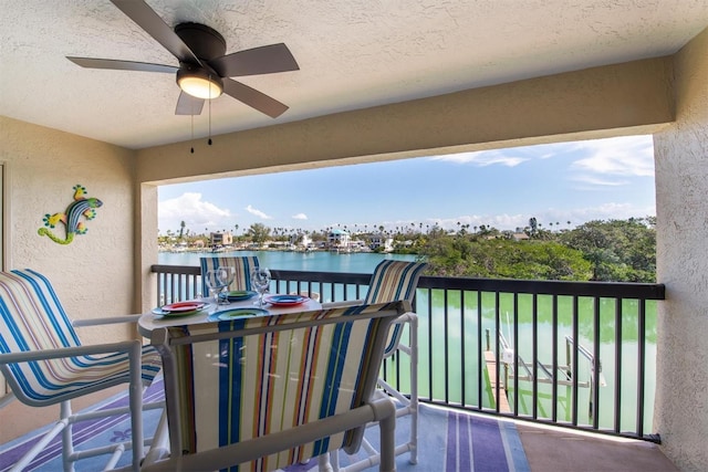 balcony with a water view and ceiling fan