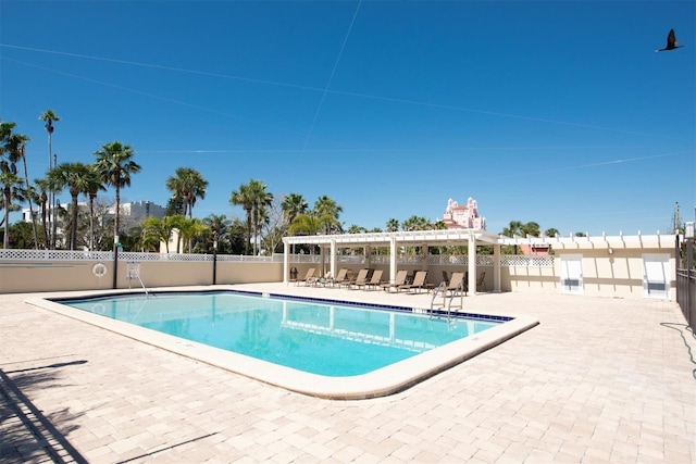 pool with a patio area, fence, and a pergola