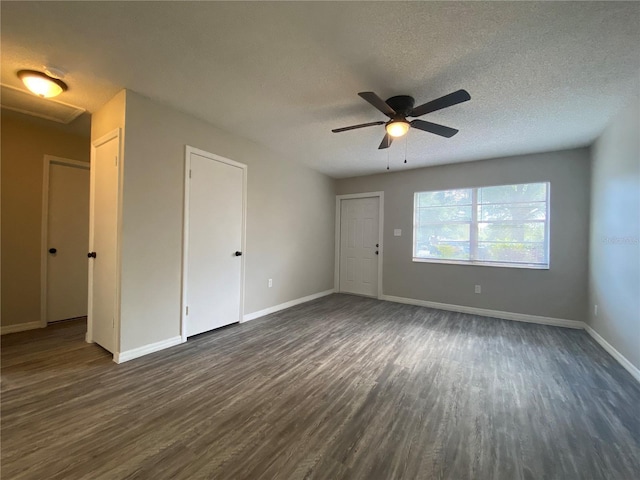 unfurnished living room with ceiling fan, a textured ceiling, baseboards, and dark wood-style flooring