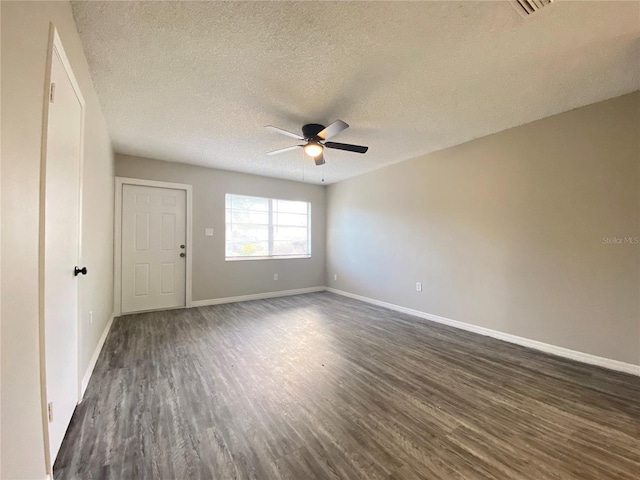 spare room featuring ceiling fan, baseboards, dark wood finished floors, and a textured ceiling