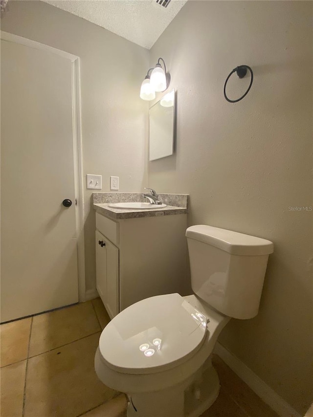 bathroom with toilet, tile patterned flooring, a textured ceiling, and vanity