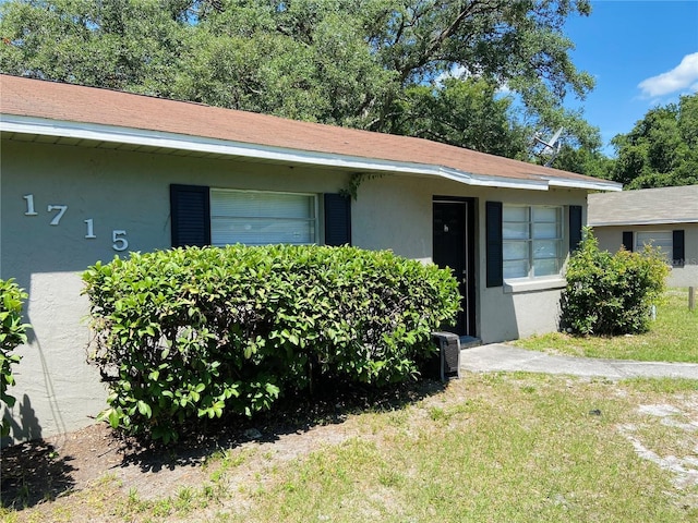 view of front of house with a front yard and stucco siding