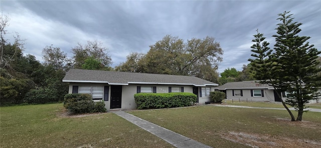 single story home with a front lawn and stucco siding