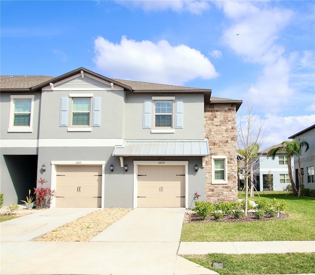 multi unit property with stone siding, concrete driveway, and stucco siding