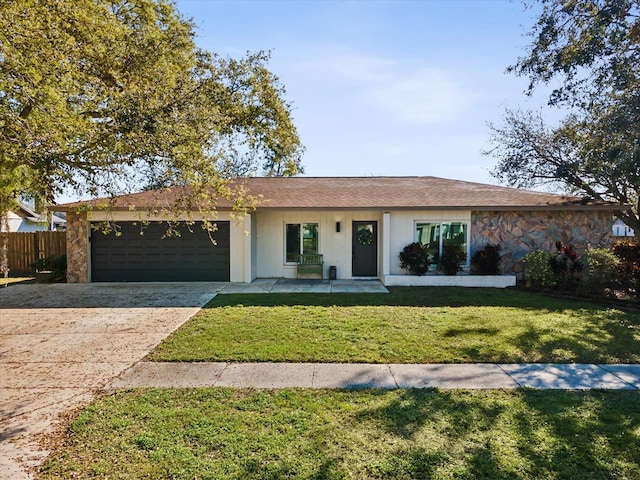 ranch-style house featuring an attached garage, fence, driveway, stone siding, and a front yard