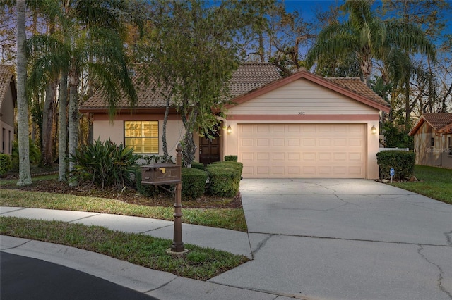 view of front of property with a garage, concrete driveway, a tiled roof, and stucco siding