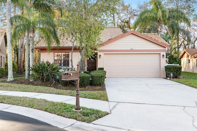 view of front of house featuring a garage, driveway, a tile roof, and stucco siding