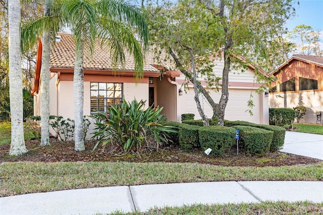 view of front of house with a tile roof, driveway, and stucco siding