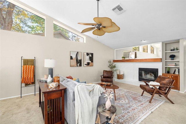 carpeted living room with baseboards, visible vents, a ceiling fan, vaulted ceiling, and a fireplace