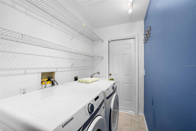 washroom with laundry area, independent washer and dryer, baseboards, and light tile patterned floors