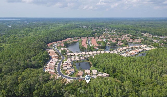 drone / aerial view featuring a water view and a forest view