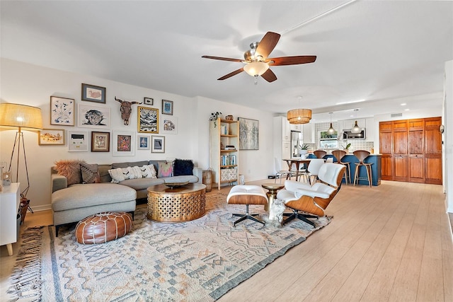 living room featuring light wood-style flooring and ceiling fan