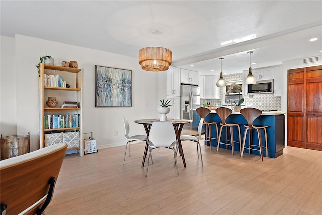 dining room with light wood-type flooring, baseboards, visible vents, and recessed lighting