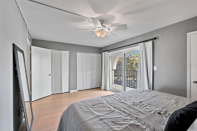 bedroom with multiple closets, access to outside, a ceiling fan, and wood finished floors