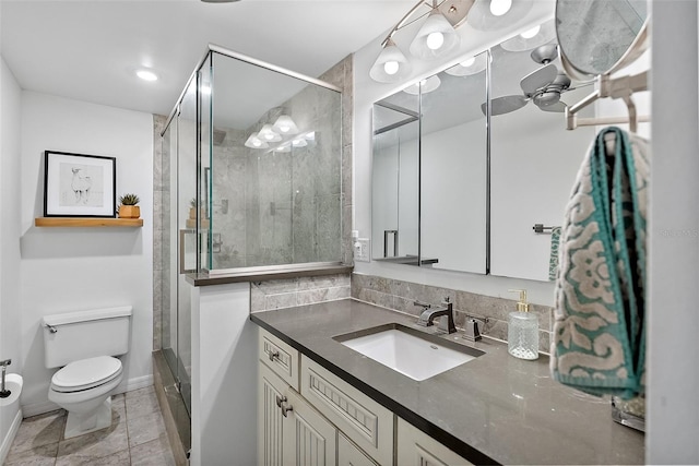 full bathroom featuring toilet, a stall shower, baseboards, and vanity