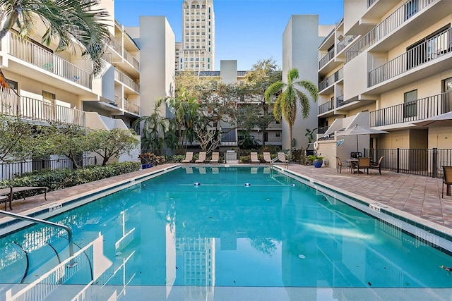 view of swimming pool with a patio area and fence