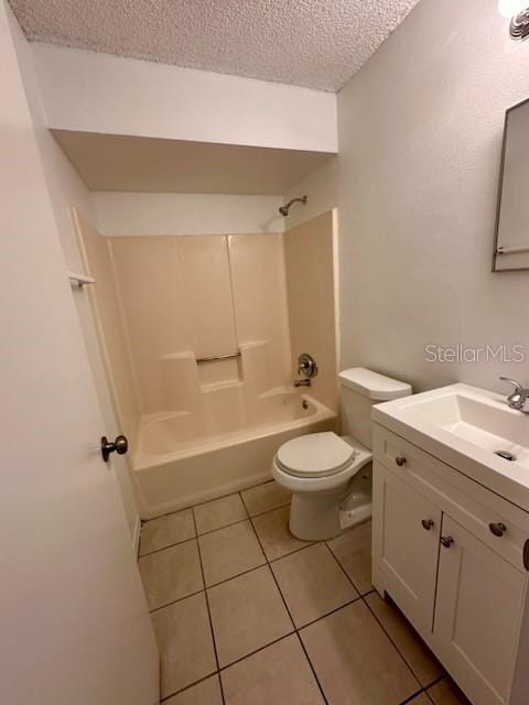 bathroom featuring vanity, tub / shower combination, a textured ceiling, tile patterned floors, and toilet