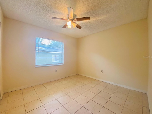 unfurnished room featuring a textured ceiling, light tile patterned floors, baseboards, and ceiling fan