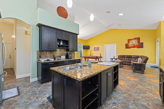 kitchen with arched walkways, decorative backsplash, lofted ceiling, open shelves, and a sink