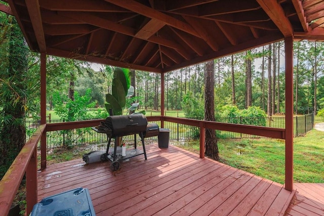 deck with a forest view, area for grilling, fence, and a gazebo