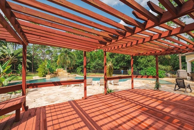 wooden terrace with a patio, an outdoor pool, fence, and a pergola